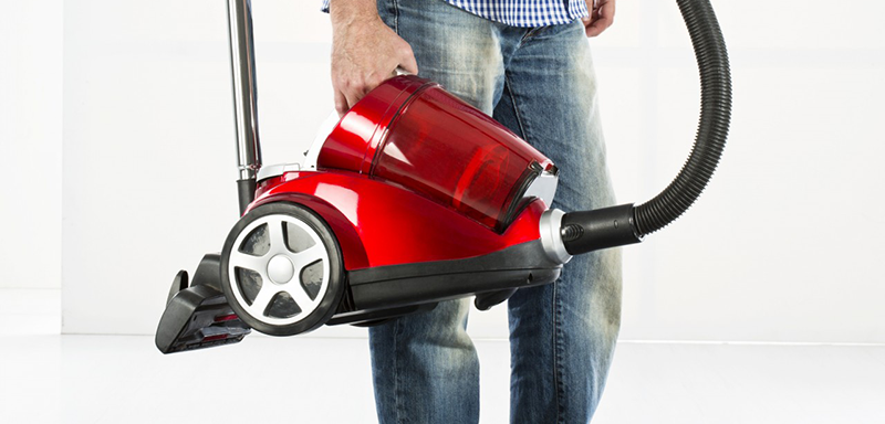 05 May 2013 --- Mature man holding vaccuum cleaner --- Image by © Roman Märzinger/Westend61/Corbis