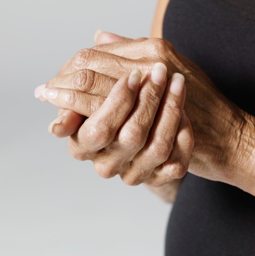 Woman with hands together --- Image by © Mark Weiss/Corbis