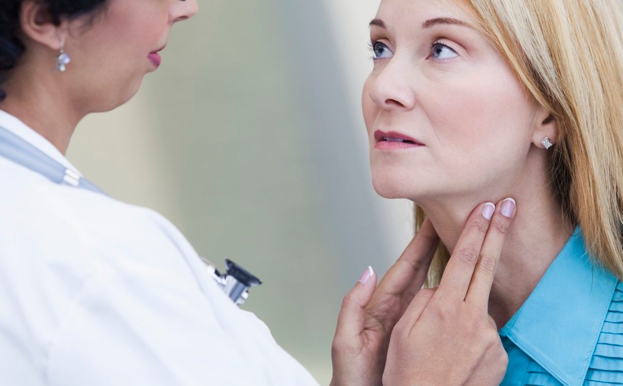 Doctor examining patient's lymph nodes --- Image by © Kate Kunz/Corbis