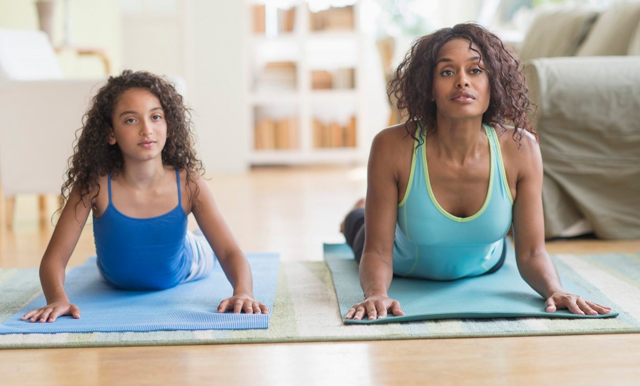 10 Jun 2014 --- Mother and daughter (8-9) exercising in living room --- Image by © Tetra Images/Corbis