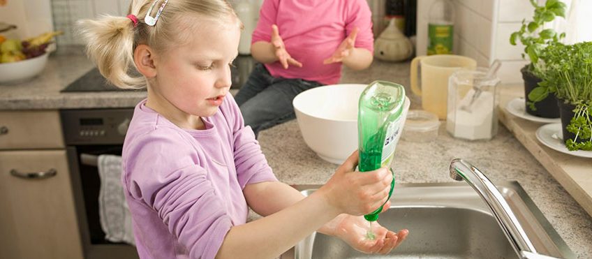 Girl washing hands, sister sitting in background --- Image by Â© Robert Niedring/Westend61/Corbis