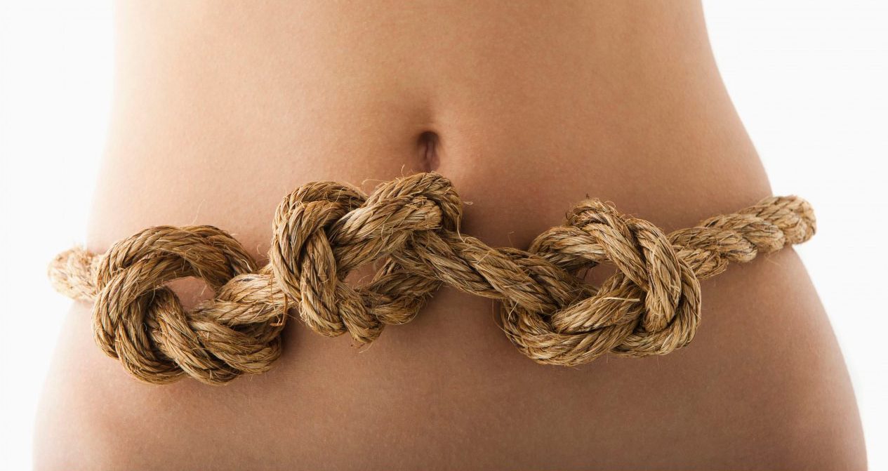 Young woman with knots in stomach --- Image by Â© Mike Kemp/Tetra Images/Corbis