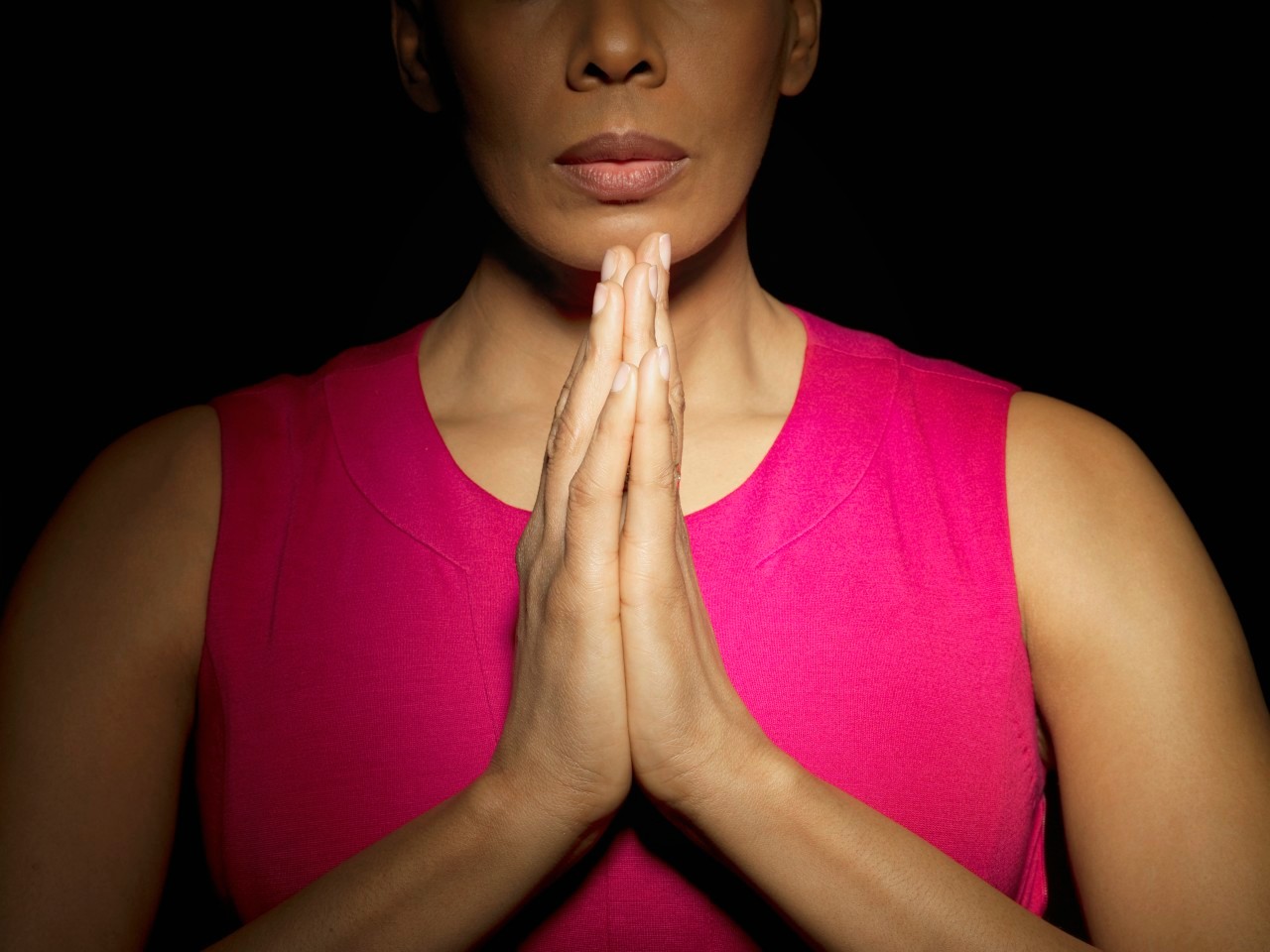 Woman with hands together --- Image by © Mark Weiss/Corbis