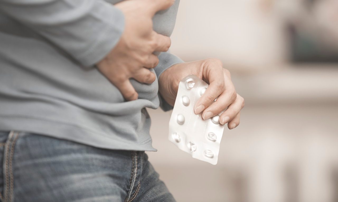 01 Feb 2015 --- Mid-section photo of the woman suffering from stomach ache with pain reliever --- Image by © Arman Zhenikeyev/Corbis