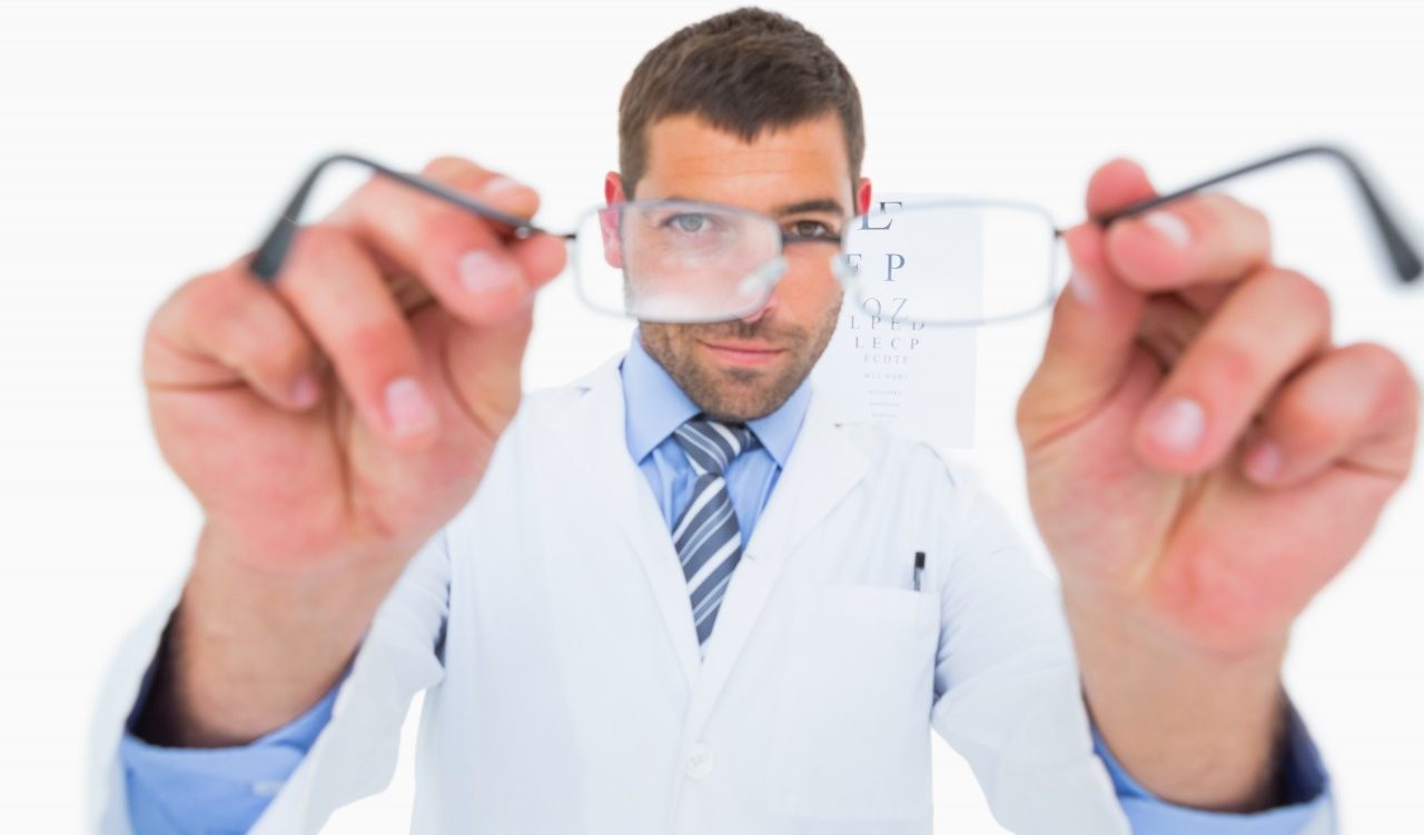 16 Sep 2014 --- Smiling optician presenting eyeglasses --- Image by © Wavebreakmedia LTD/Wavebreak Media Ltd./Corbis