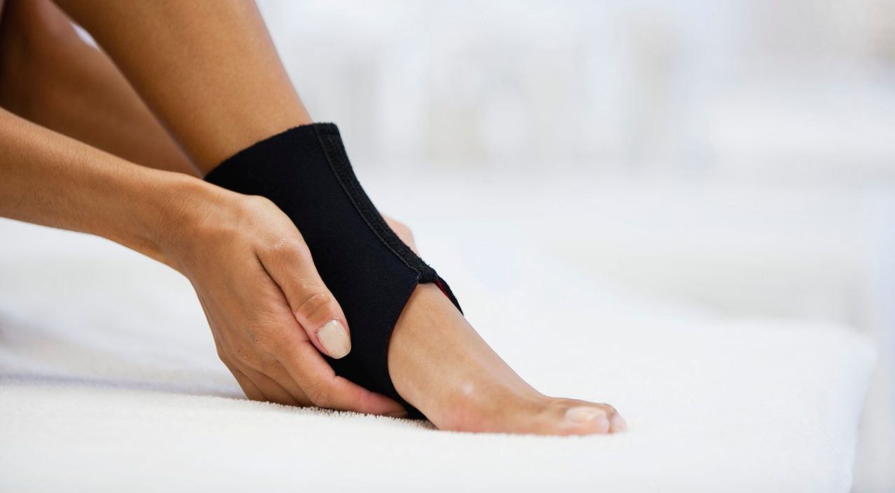 Woman wearing ankle brace, low section --- Image by © Odilon Dimier/PhotoAlto/Corbis