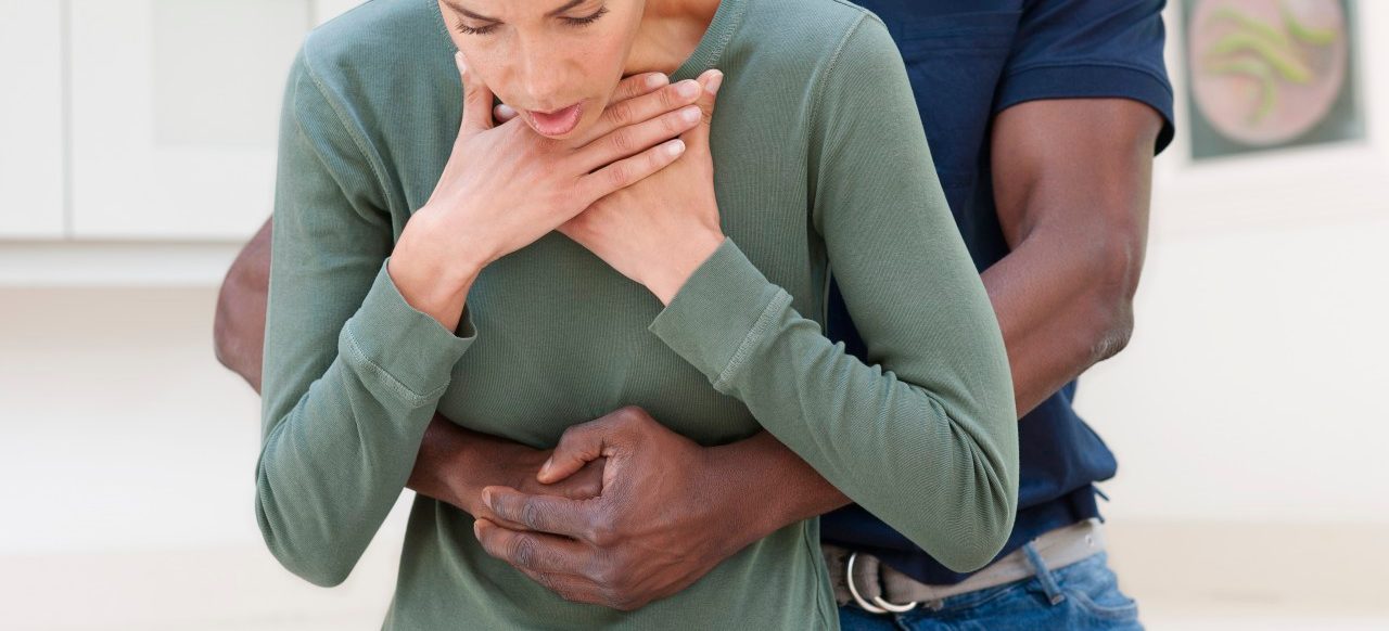 Heimlich manoeuvre. Man performing the Heimlich manoeuvre on a choking woman. --- Image by © Science Photo Library/Corbis