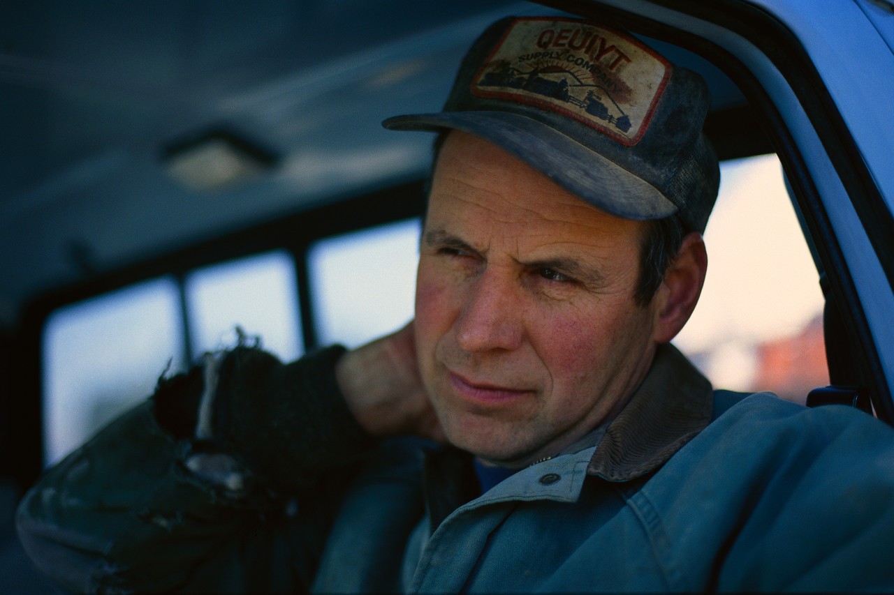 Farmer Rubbing Neck in Pickup Truck --- Image by © Little Blue Wolf Productions/Corbis