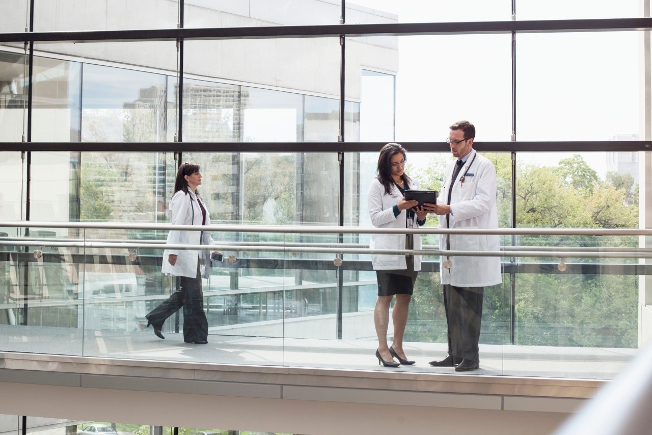 Three doctors in hospital walkway --- Image by © Samantha Mitchell/Corbis