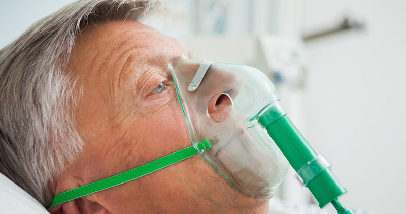 Mallorca, Spain --- Man in bed with oxygen mask --- Image by Â© Wavebreak Media Ltd./Corbis