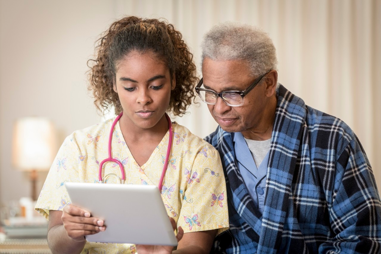 12 Dec 2013 --- African American nurse and patient using digital tablet --- Image by © Terry Vine/Blend Images/Corbis