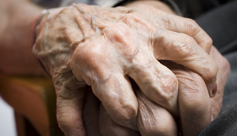 Close-up of a senior couple holding hands of each other --- Image by Â© Mike Kemp/Rubberball/Corbis