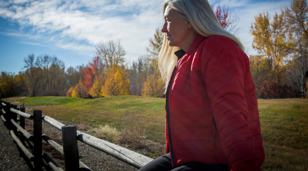 25 Oct 2014 --- Older Caucasian woman sitting on wooden fence --- Image by © Steve Smith/Blend Images/Corbis