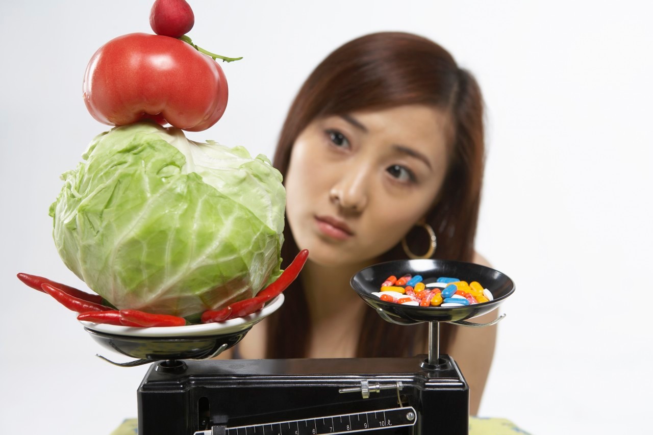 Young Woman With Healthy Food And Pills On Scales --- Image by © Blue Jean Images/Corbis
