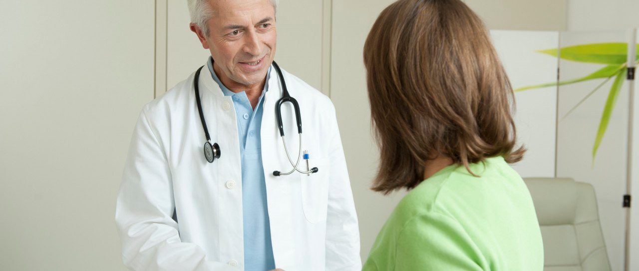 Doctor and female patient shaking hands --- Image by © Petrol/Corbis