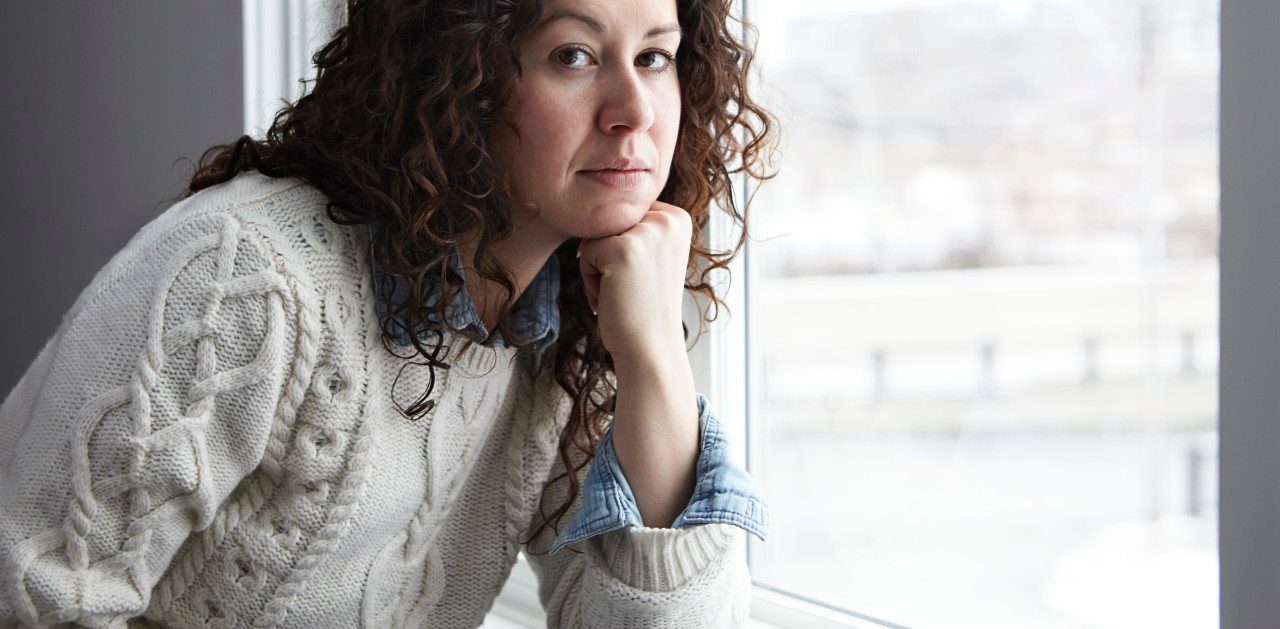 Portrait of woman thinking by window --- Image by © Darren Kemper/Corbis