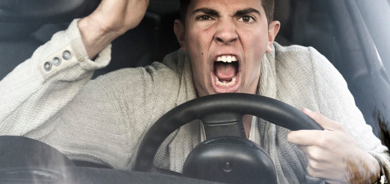 young man gets angry while driving the car --- Image by © Sandra Hoever/Corbis