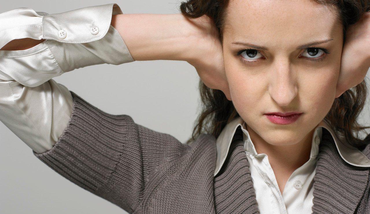 Businesswoman with hands over ears --- Image by © Beau Lark/Corbis