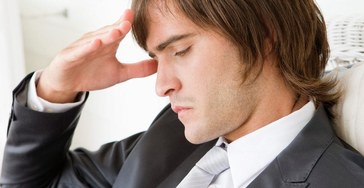 Close-up of a man suffering from a headache --- Image by © Fabrice Lerouge/Onoky/Corbis