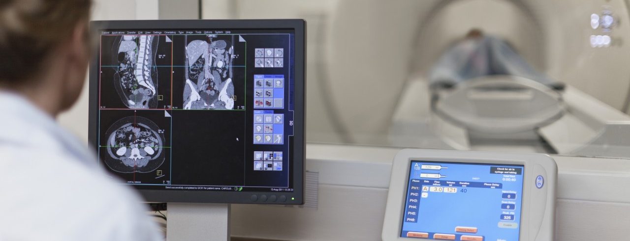 Doctor operating CT scanner in hospital --- Image by © Hybrid Images/cultura/Corbis