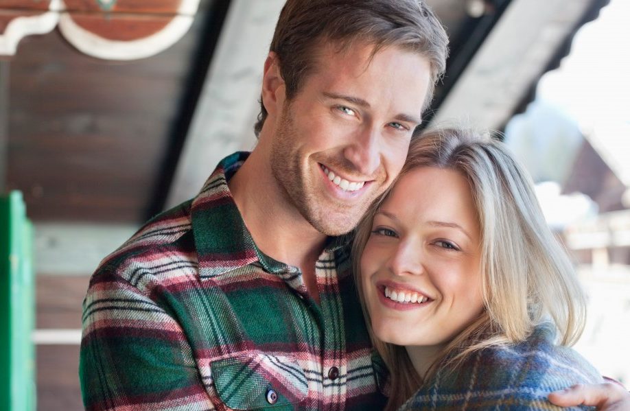 Switzerland, Switzerland --- Portrait of smiling couple hugging on cabin porch --- Image by © 237/Sam Edwards/Ocean/Corbis