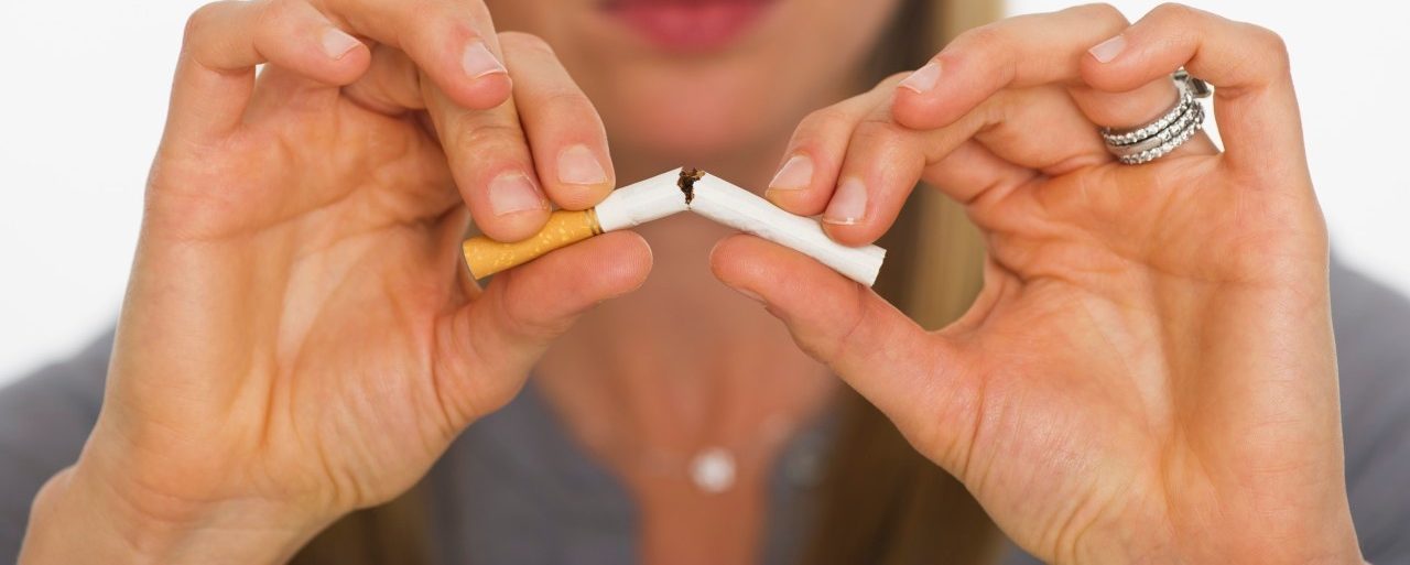 Young woman breaking cigarette --- Image by © Tetra Images/Corbis