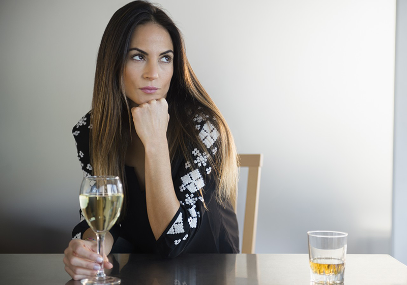 14 Nov 2014 --- Lonely Caucasian woman drinking white wine in bar --- Image by © Jamie Grill/Blend Images/Corbis