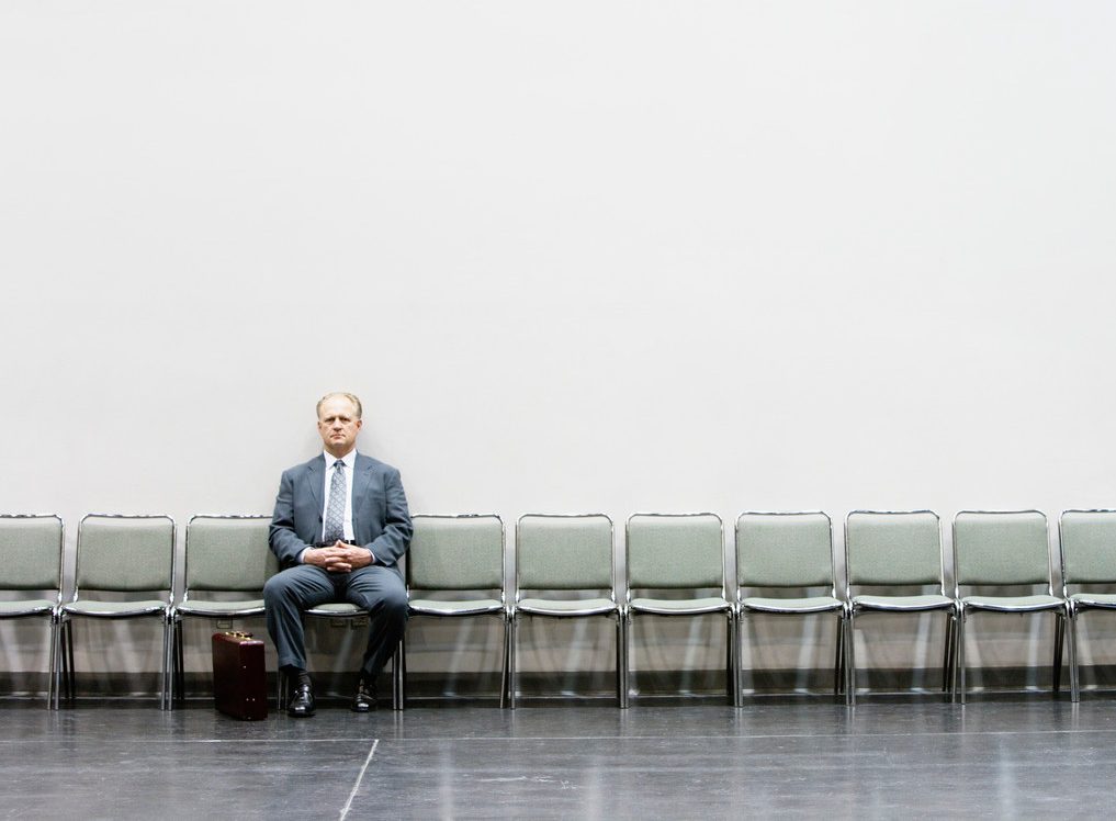 Businessman Alone in Row of Chairs --- Image by © Corbis