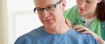 Nurse examining senior male patient.