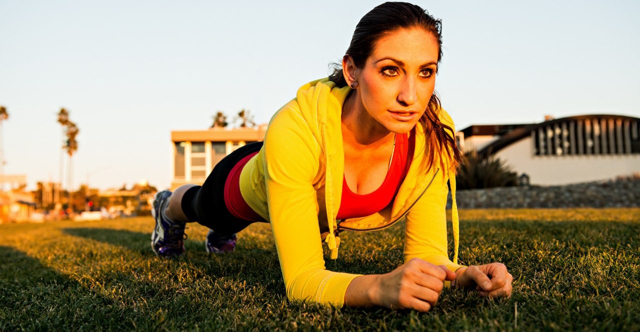 Woman practicing yoga on green lawn --- Image by © Corey Jenkins/Image Source/Corbis
