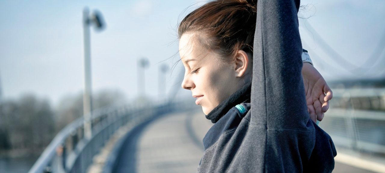 22 Nov 2014, Magdeburg, Germany --- Young woman doing stretching exercise after jogging --- Image by © Sebastian Gauert/Westend61/Corbis