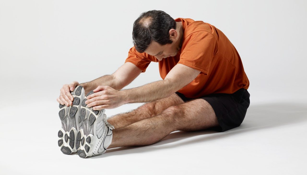 Man stretching --- Image by © Mark Weiss/Corbis