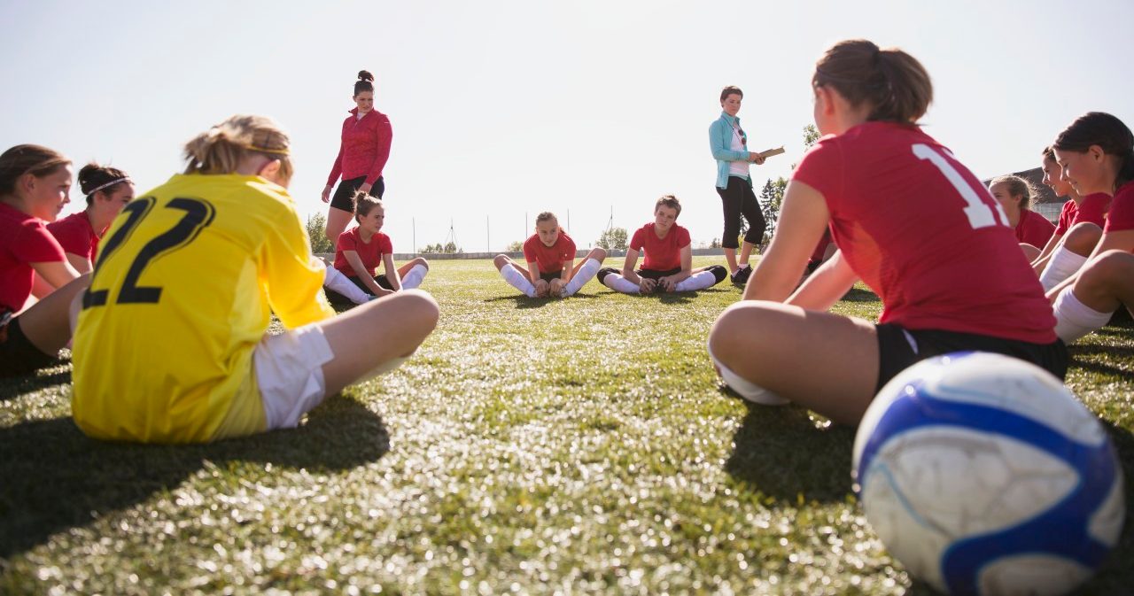 21 Sep 2012 --- Girls soccer team stretching before game. --- Image by © Hero Images/Corbis
