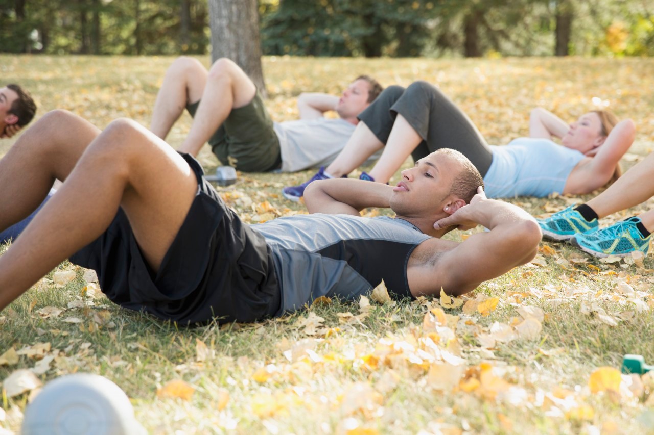 19 Sep 2012 --- Bootcamp class doing sit-ups outdoors. --- Image by © Hero Images/Corbis